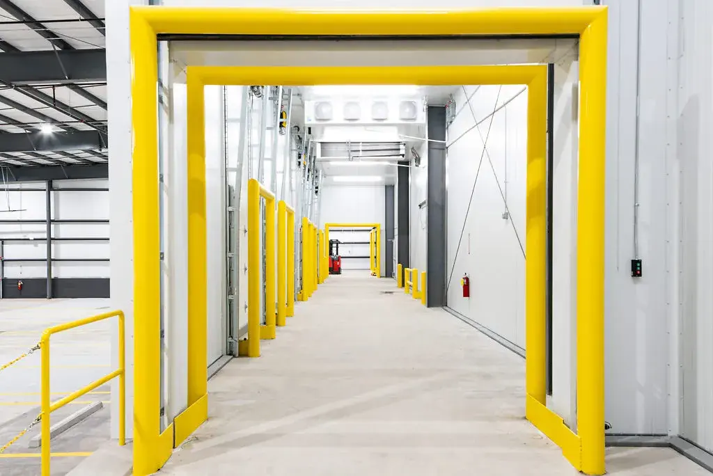 A bright yellow door and frame contrast beautifully with a pristine white wall