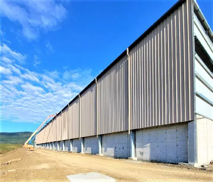 A significant industrial facility with a large metal roof, highlighting its strength and utilitarian design