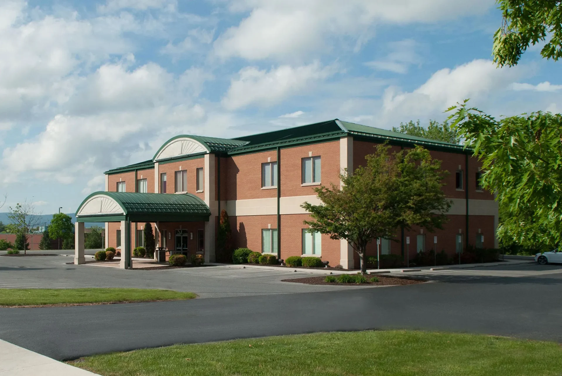Carlisle-PA-Commercial-Contractor-Galbraith A modern two-story brick building with a green awning and a clear blue sky