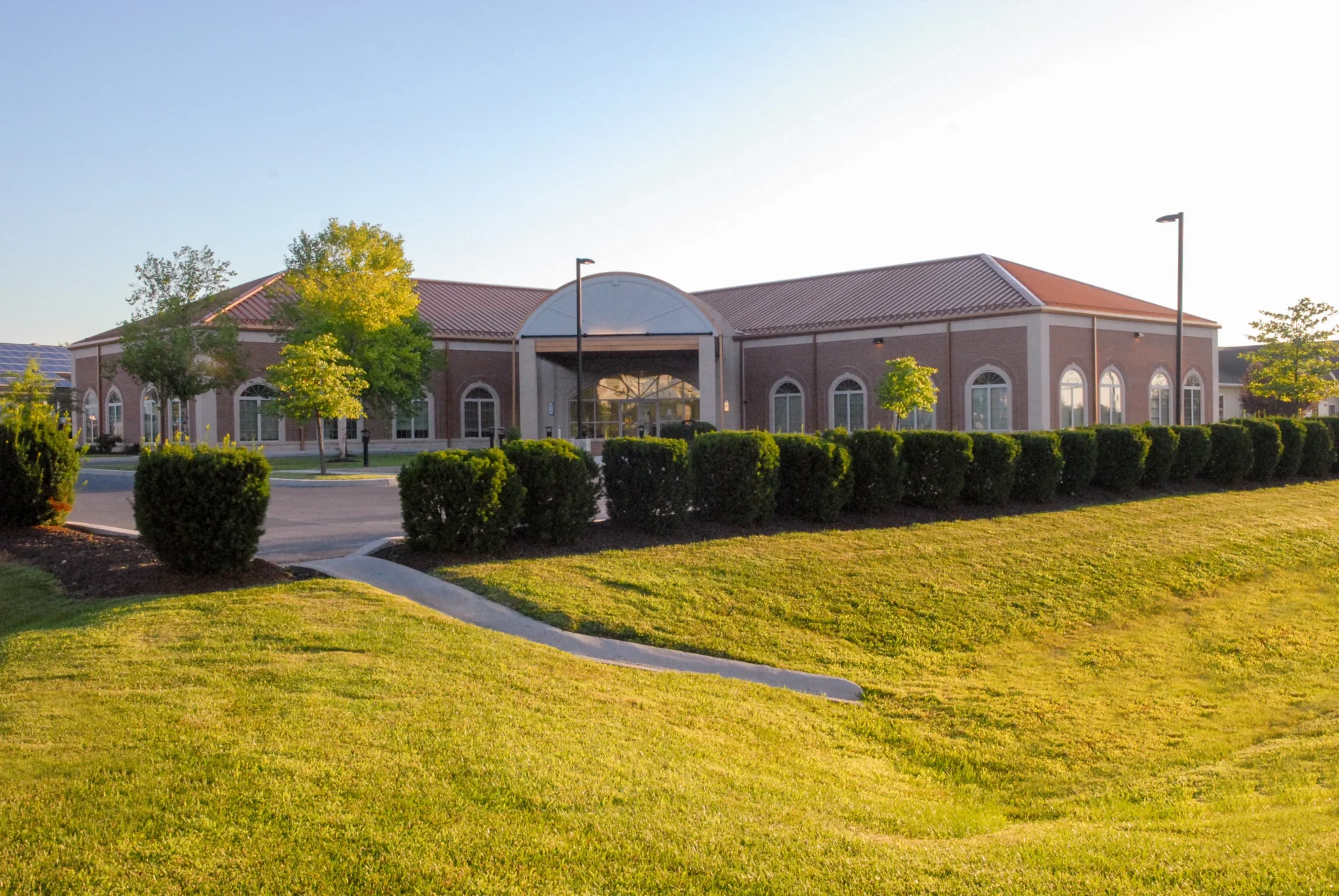 Galbraith_DSC_0062-LR-PS A modern brick building with arching windows and a green landscaped lawn during daylight