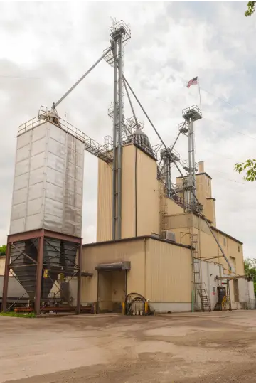 Industrial grain elevator and silos with an American flag flying above